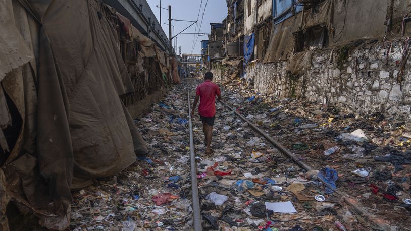 FILE - A man walks on a railway track littered with plastic and other waste materials on Earth Day in Mumbai, India, April 22, 2024. (AP Photo/Rafiq Maqbool, File)