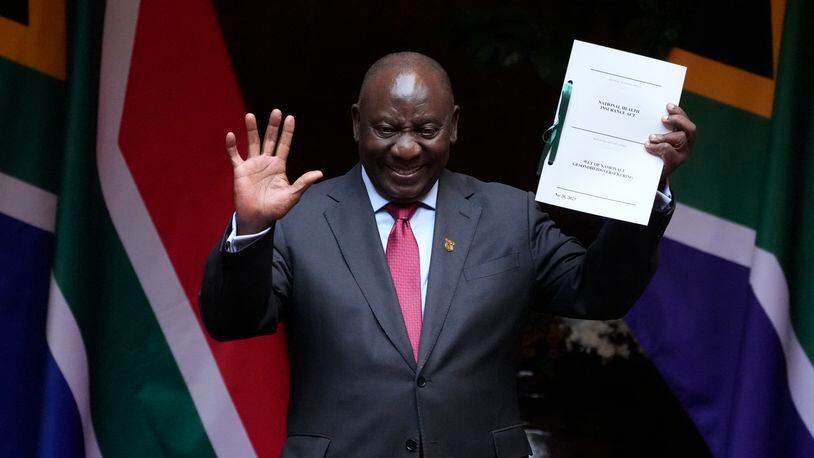 FILE — South African President Cyril Ramaphosa shows the signed bill for National Health Insurance signed into law in Pretoria, South Africa, Wednesday, May 15, 2024. Several polls have the African National Congress' support below 50% ahead of next Wednesday's, May 29, 2024 vote, raising the prospect that it might not be the majority party for the first time since Nelson Mandela led it to victory in the first all-race elections that ended white minority rule in 1994. (AP Photo/Themba Hadebe, File)