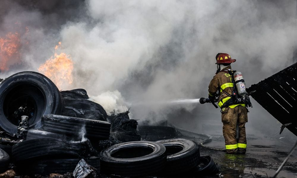 Crews fight a fire in piles of tires in the 1400 block of Leonhard Street May 20, 2024, in the Old North Dayton neighborhood that created a massive plume of black smoke that could be seen for miles. JIM NOELKER/STAFF