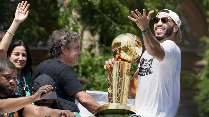 Boston Celtics' Jayson Tatum, right, and Celtics owner Wyc Grousbeck, center, celebrate their NBA basketball championship with a duck boat parade Friday, June 21, 2024, in Boston. (AP Photo/Michael Dwyer)