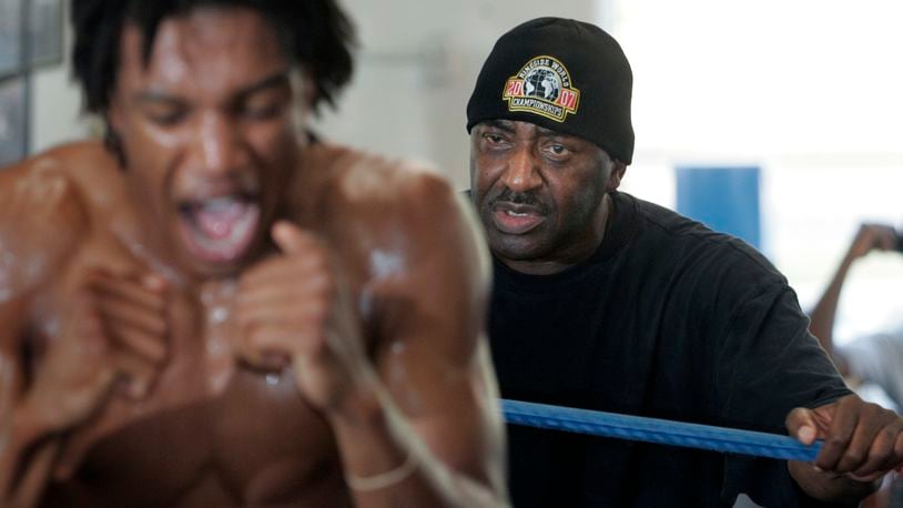 Trainer Ron Daniels watches intently from just beyond the ring ropes as boxer Miles Jackson works out back in 2010. Dayton Daily News file photo