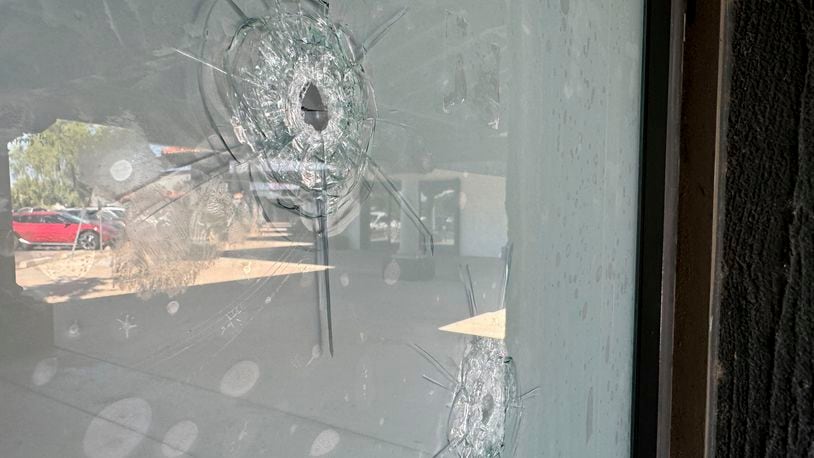 Bullet holes remain in the glass window at a Democratic Party campaign office in Tempe, Ariz., Wednesday, Sept. 25, 2024. (AP Photo/Gabriel Sandoval)