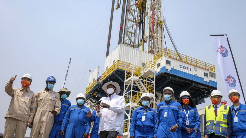 FILE - Uganda's President Yoweri Museveni, center, accompanied by workers from China Oilfield Services Limited (COSL) and the China National Offshore Oil Corporation (CNOOC), inaugurates the start of drilling at the Kingfisher oil field on the shores of Lake Albert in the Kikuube district of western Uganda Tuesday, Jan. 24, 2023. (AP Photo/Hajarah Nalwadda, File)