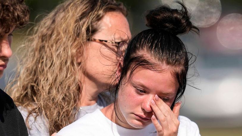 A student weeps at a makeshift memorial after a shooting Wednesday at Apalachee High School, Thursday, Sept. 5, 2024, in Winder, Ga. (AP Photo/Mike Stewart)