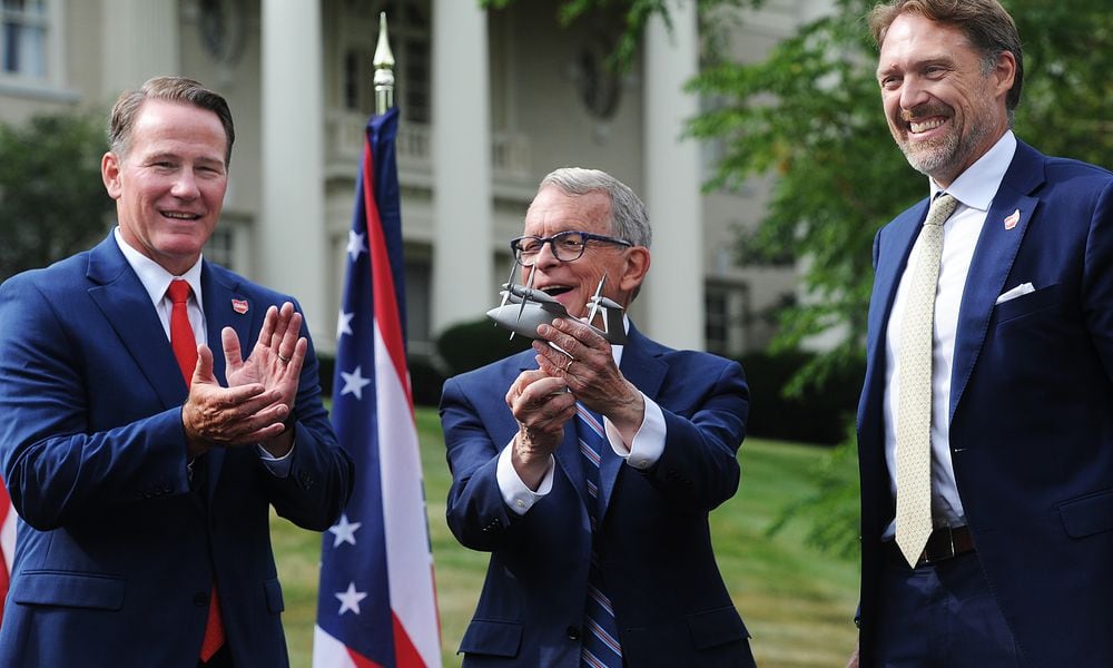 Lt. Gov. Jon Husted, left, and Ohio Gov. Mike DeWine applaud Joby Aviation Inc. founder JoeBen Bevirt, at far right, at Hawthorn Hill, the home of Orville Wright, in Oakwood after he announced Monday, Sept. 18, 2023, his company's pledge to bring thousands of jobs to the region at a facility near Dayton International Airport that specializes in the production of 