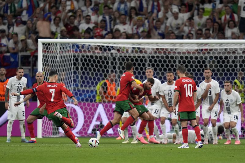 Portugal's Cristiano Ronaldo shots a free kick during a round of sixteen match between Portugal and Slovenia at the Euro 2024 soccer tournament in Frankfurt, Germany, Monday, July 1, 2024. (AP Photo/Matthias Schrader)