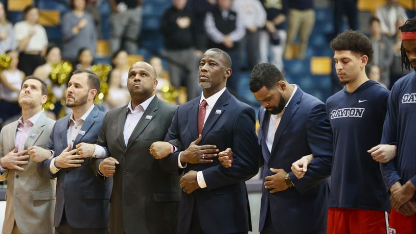 Dayton coach Anthony Grant, center, stands for the national anthem before a game against La Salle on Tuesday, Jan. 23, 2024, at Tom Gola Arena in Philadelphia. David Jablonski/Staff