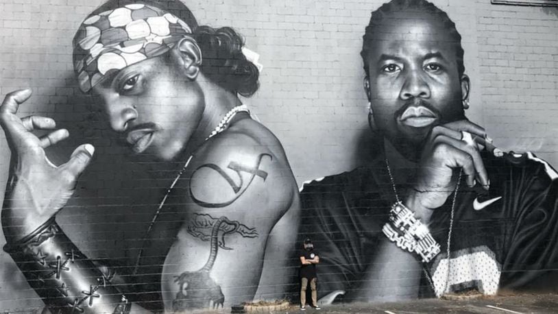 North Carolina artist JEKS (at bottom center) poses Sunday in front of a 30-foot-tall mural of Atlanta hip-hop legends OutKast. The mural was painted on the side of a building in Atlanta's Little Five Points neighborhood.