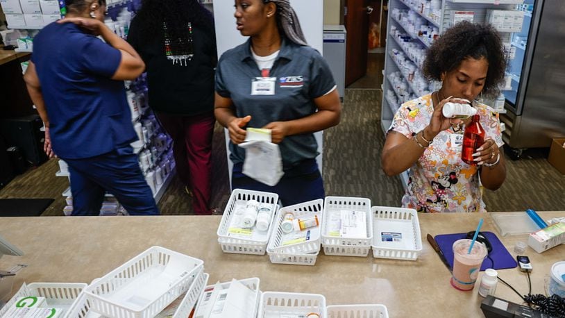 Pharmacy technicians for Ziks Pharmacy on West Third Street Jasmine Woodard, right and Joy Duaka, center, prep medications at the store on Monday, July 1, 2024. The closing of many pharmacies around Dayton is making it harder for residents to get their medications and harder for the pharmacies left to meet growing demands. JIM NOELKER/STAFF