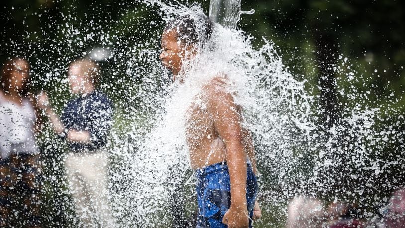 Kids and adults enjoyed the splash pad at Island MetroPark Tuesday June 18, 2024. This week the Dayton area is expecting near100 degree temperatures all week. JIM NOELKER/STAFF