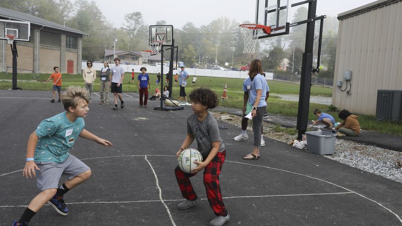 Boys play basketball at the Project:Camp pop-up daycamp for families impacted by Hurricane Helene in Brevard, N.C., Monday, Oct. 7, 2024. (AP Photo/Gabriela Aoun Angueira)