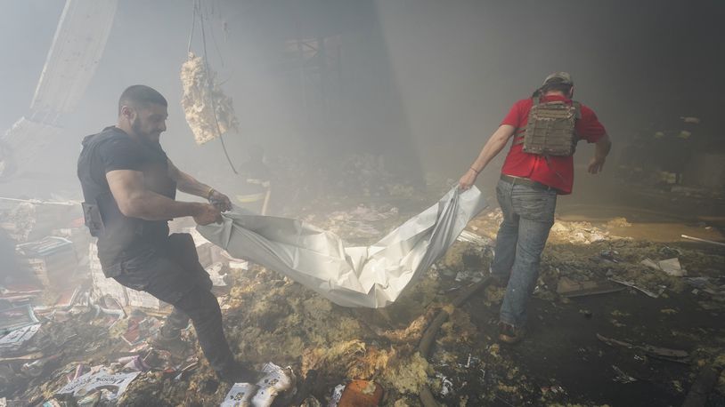 Rescuers carry a body after a Russian missile hit a large printing house in Kharkiv, Ukraine, Thursday, May 23, 2024. Russian missiles slammed into Ukraine’s second-largest city in the northeast of the country and killed at least seven civilians early Thursday, officials said, as Kyiv’s army labored to hold off an intense cross-border offensive by the Kremlin’s larger and better-equipped forces. (AP Photo/Andrii Marienko)