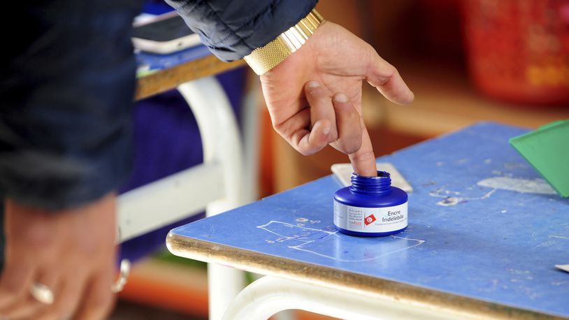 FILE - A man dips his finger in ink after casting his ballot at a polling station in Tunis, Saturday, Dec. 17, 2022. (AP Photo/Hassene Dridi, File)