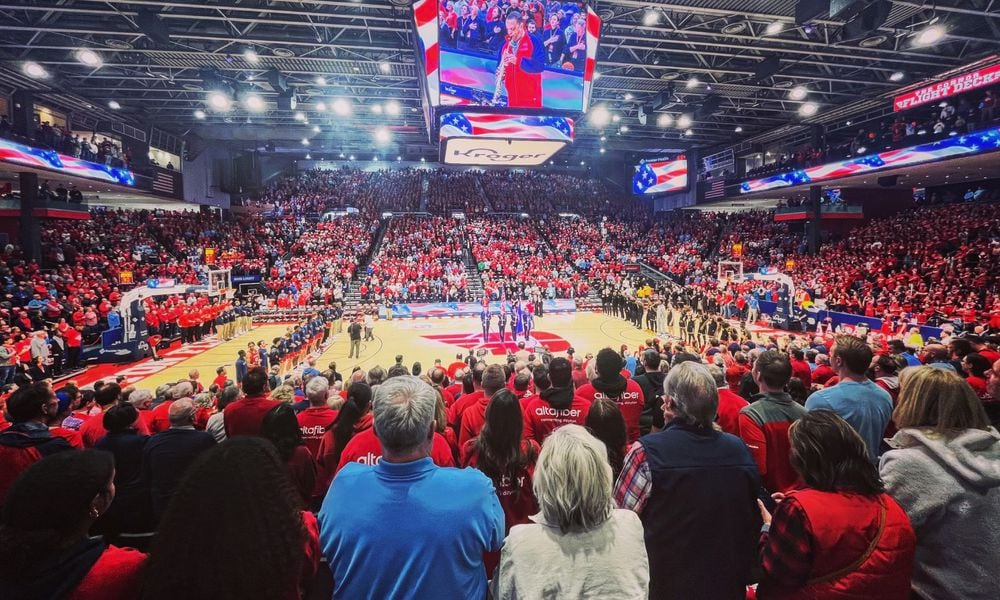 Dayton and Virginia Commonwealth stand for the national anthem before a game on Friday, March 8, 2024, at UD Arena. David Jablonski/Staff