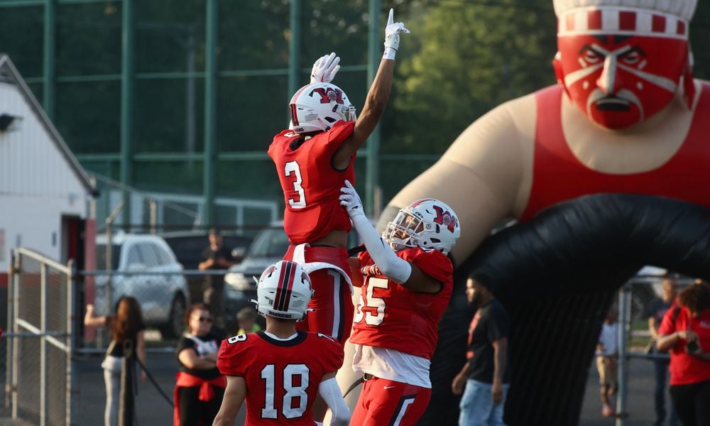 Wayne's Teaunn Hunter, top, and Chris Johnson celebrate a touchdown against Fairfield on Friday, Aug.18, 2023, at Heidkamp Stadium in Huber Heights. David Jablonski/Staff