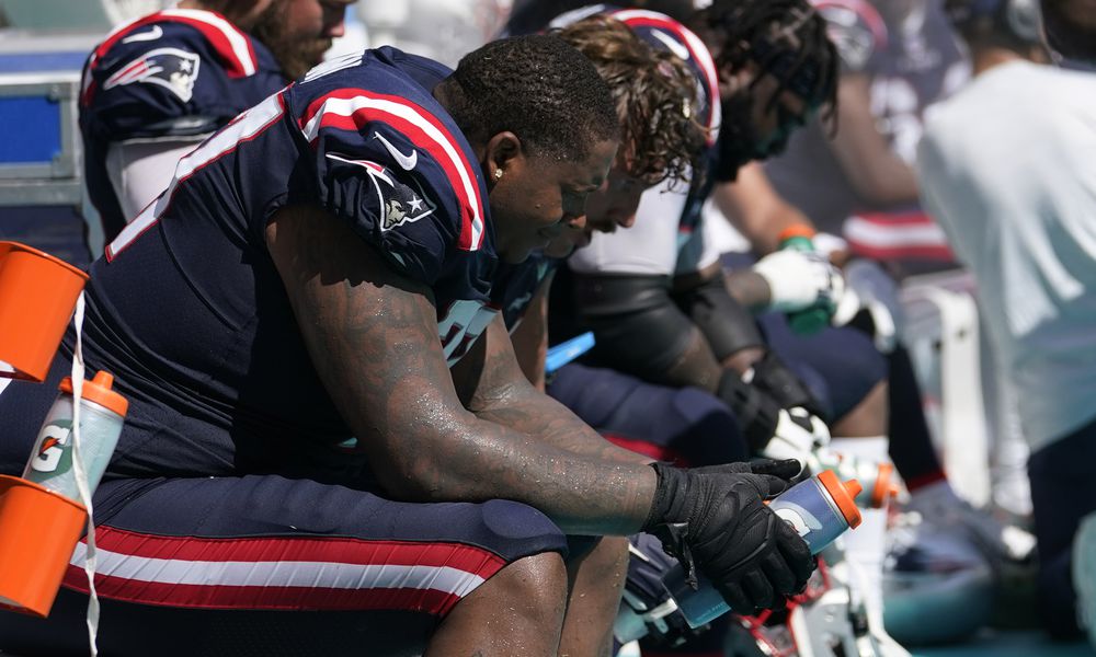 New England Patriots offensive tackle Trent Brown (77) and his teammates sit on the sidelines during the second half of an NFL football game against the Miami Dolphins, Sunday, Sept. 11, 2022, in Miami Gardens, Fla. The Dolphins defeated the Patriots 20-7. (AP Photo/Lynne Sladky)