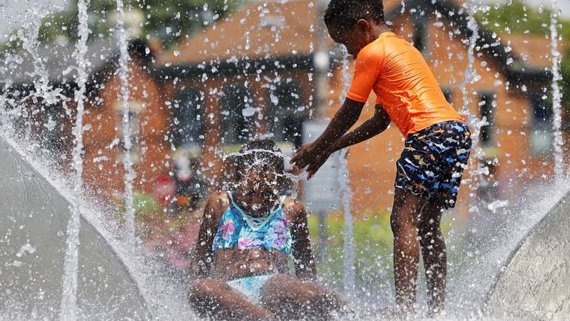 Dadiso Mupeyiwa, 9, left, and Mukundi Mupeyiwa, 6, play in the water at Marcum Park Wednesday, July 20, 2022, in Hamilton. NICK GRAHAM/STAFF