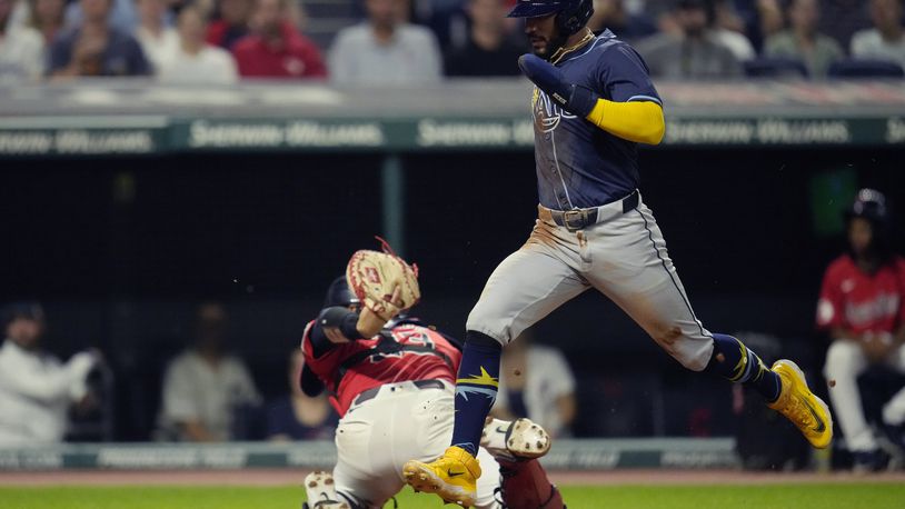 Tampa Bay Rays' José Caballero, right, scores behind Cleveland Guardians catcher Bo Naylor, left, in the fourth inning of a baseball game Thursday, Sept. 12, 2024, in Cleveland. (AP Photo/Sue Ogrocki)