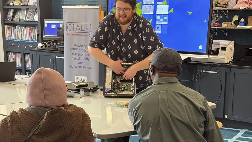 In this undated photo, Richie Hull, a lead instructor at the Connecticut-based group CfAL for Digital Inclusion, teaches participates at the Ives Maine Library in New Haven, Conn. how to take a computer apart and put it back together again. Connecticut is working on a new online academy to teach citizens about how to use generative artificial intelligence, but groups like CfAL say basic computer skills are also needed. (Rose Servetnick/CfAL for Digital Inclusion via AP)