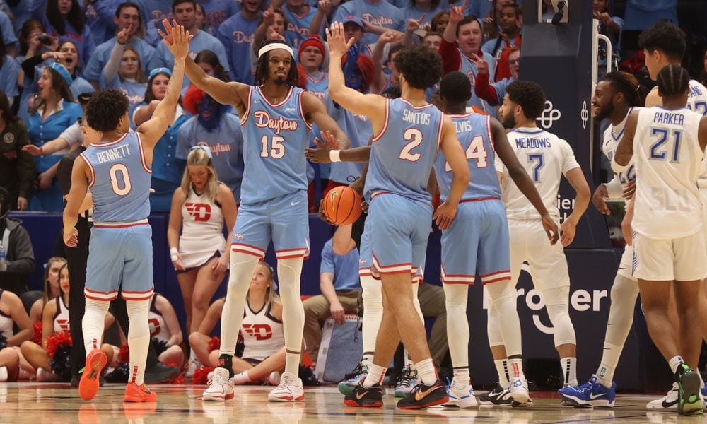 Dayton players slap hands with DaRon Holmes II after a defensive stop against Saint Louis on Tuesday, Jan. 16, 2024, at UD Arena. David Jablonski/Staff