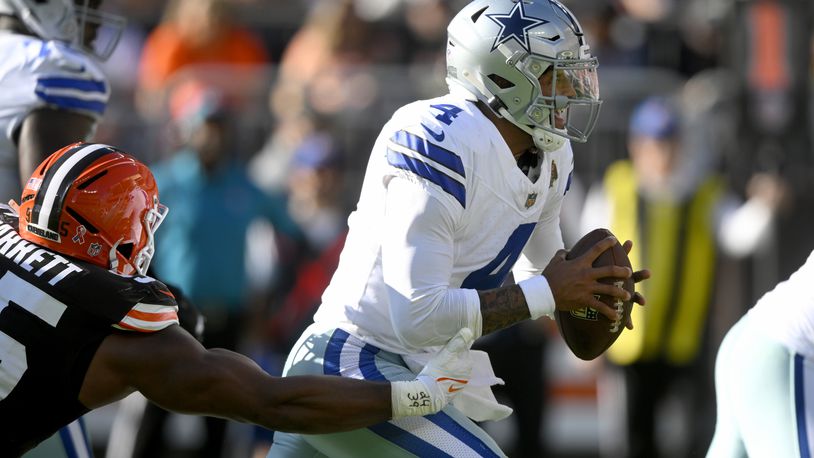 Dallas Cowboys quarterback Dak Prescott (4) scrambles away from pressure by Cleveland Browns defensive end Myles Garrett, left, in the first half of an NFL football game in Cleveland, Sunday, Sept. 8, 2024. (AP Photo/David Richard)