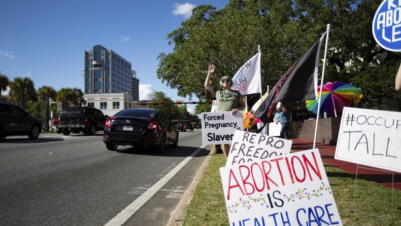 FILE - A small crowd holding signs and waving as cars pass by the Leon County Courthouse, protests Sb 300, which bans abortions after six weeks, Thursday, April 13, 2023. in Tallahassee, Fla. (Alicia Devine/Tallahassee Democrat via AP)