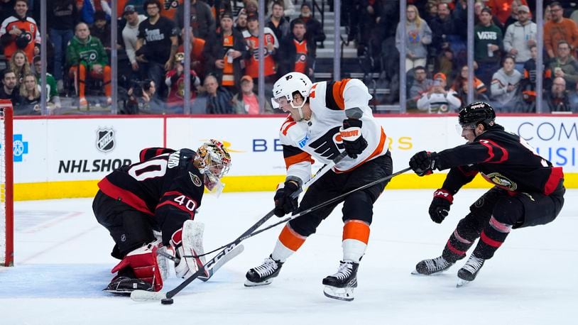 FILE - Philadelphia Flyers' Tyson Foerster, center, tries to shoot past Ottawa Senators' Mads Sogaard, left, as Senators' Shane Pinto, right, defends during the second period of an NHL hockey game March 2, 2024, in Philadelphia. (AP Photo/Matt Slocum, File)