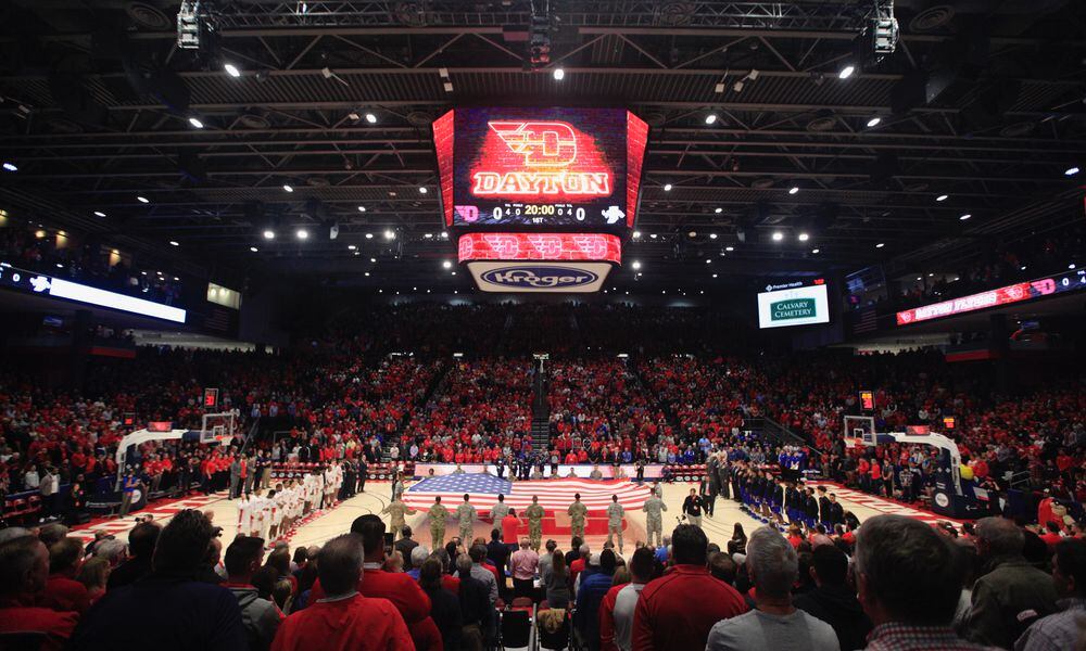 PHOTOS FROM THE BOOK: The Epicenter of College Basketball: A History of UD Arena Fans stand for the national anthem before a game between Dayton and Indiana State in 2019 at UD Arena. This was the first mens basketball game since the end of a three-year renovation project that transformed the 50-year old arena. Dayton Daily News photo by David Jablonski