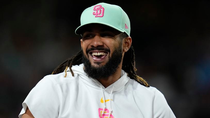 San Diego Padres's Fernando Tatis Jr. smiles in the dugout during the seventh inning of a baseball game against the New York Mets, Friday, Aug. 23, 2024, in San Diego. (AP Photo/Gregory Bull)