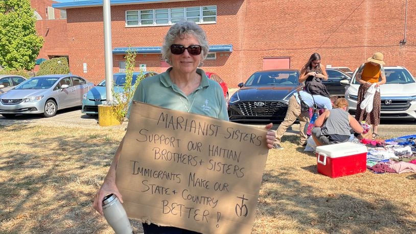 An attendee of a Dayton rally in support of Haitian Springfield residents on Sunday held a sign in support of immigrants.