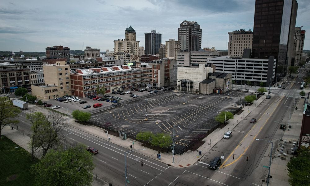 A city of Dayton-owned parking lot on the south side of East Second Street sits empty, taking up most of the land between St. Clair Street (foreground) and Jefferson Street. JIM NOELKER / STAFF