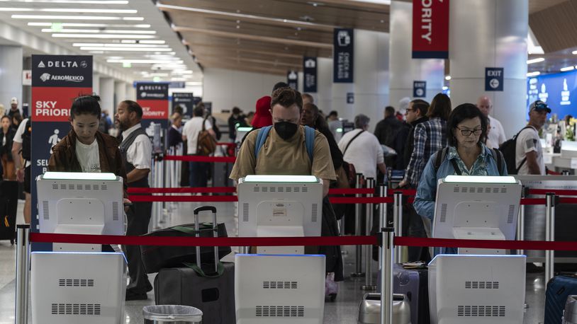 Travelers use kiosks to check in for flights in the Delta Airlines ticketing area at the Los Angeles International Airport in Los Angeles, Friday, Aug. 30, 2024. (AP Photo/Jae C. Hong)