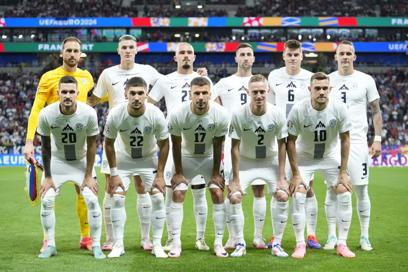 Slovenia starting players pose for a team photo at the beginning of a round of sixteen match between Portugal and Slovenia at the Euro 2024 soccer tournament in Frankfurt, Germany, Monday, July 1, 2024. (AP Photo/Ebrahim Noroozi)