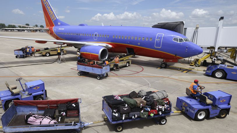 FILE - In this June 19, 2014 file photo, baggage carts are towed to the Boeing 737 jet at Bill and Hillary Clinton National Airport in Little Rock, Ark., June 19, 2014. Devices powered by lithium-ion batteries are overheating more often during airline flights and passengers often put them in checked bags that go into the cargo hold, where a fire might not be detected as quickly. (AP Photo/Danny Johnston, File)