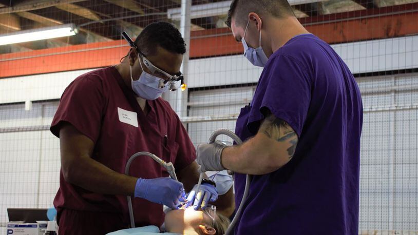 U.S. Navy Reserve Lt. Cmdr. Nathan Ocasio (left), Expeditionary Medical Facility Dallas One dentist, Fort Worth, Texas, and U.S. Air Force Staff Sgt. Stephen Clark, dental technician, 88th Medical Group, Wright-Patterson Air Force Base, provide dental care during Innovative Readiness Training Appalachian Care 2019 at Wise County Fairgrounds, Wise, Va., Aug. 19. (Air National Guard photo/1st Lt. Andrew Layton)