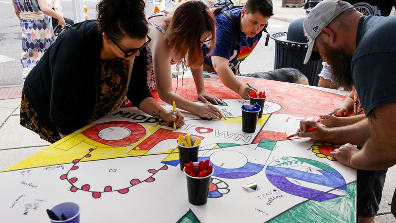 Attendees color a large pride art project during the 5th annual Middletown Pride celebration Friday, June 23 2023. NICK GRAHAM/STAFF