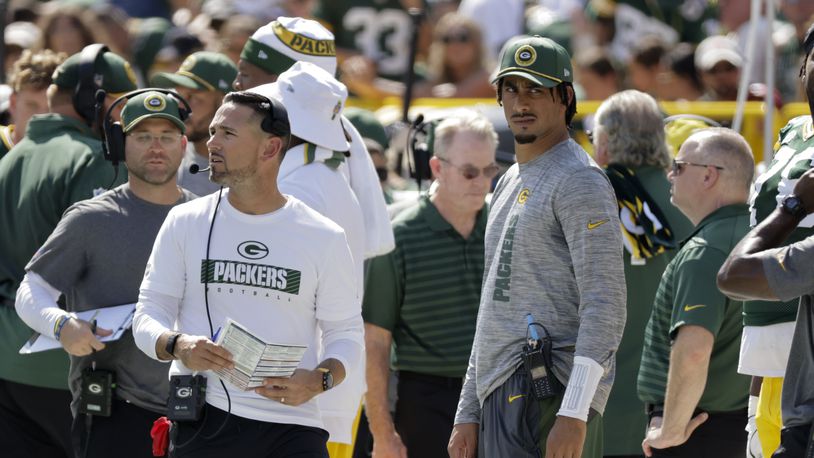 Injured Green Bay Packers quarterback Jordan Love looks on as head coach Matt LaFleur walks by during the first half of an NFL football game against the Indianapolis Colts Sunday, Sept. 15, 2024, in Green Bay, Wis. (AP Photo/Mike Roemer)