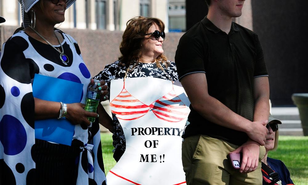 Ann Marie, proudly wears her 'Property of Me' sign Monday, June 24, 2024 at the Federal Building in Dayton while protesting anti-abortion efforts across the country and the Supreme Court's Dobbs decision two years ago. MARSHALL GORBY\STAFF