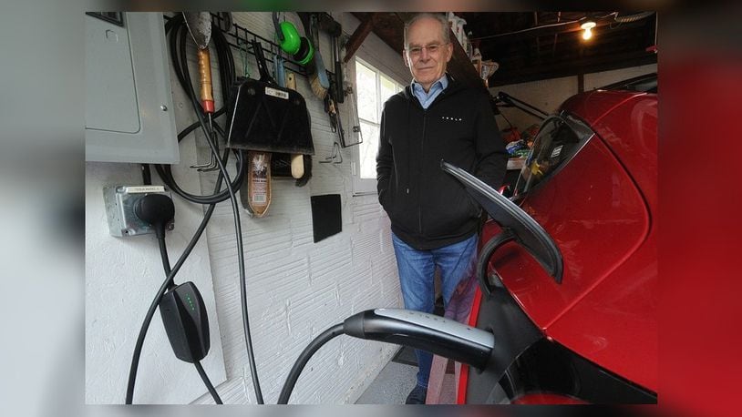 Tim Benford, Chapter President of Drive Electric Dayton, charges his electric car at his home in Oakwood. MARSHALL GORBY\STAFF