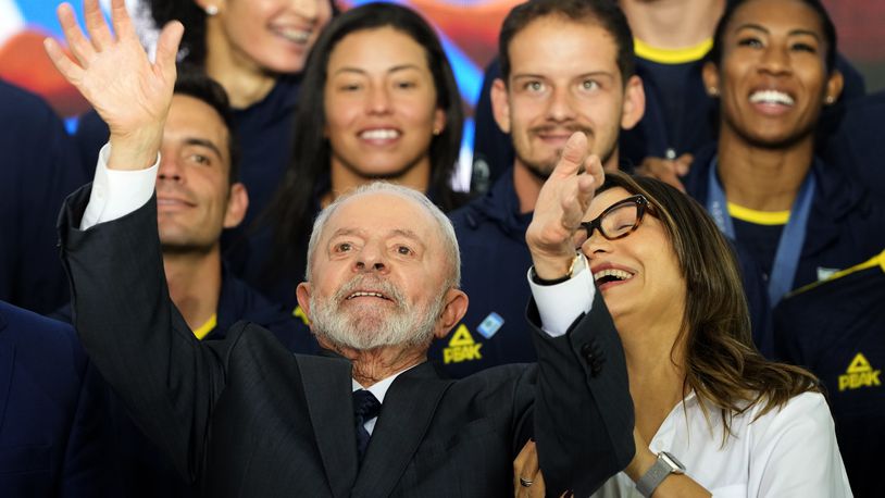 Brazil's President Luiz Inacio Lula da Silva celebrates with the first lady Rosangela da Silva and athletes from the Brazilian delegation who participated in the Paris Olympic Games, during a meeting at the Planalto presidential palace, in Brasilia, Brazil, Monday, Aug. 26, 2024. (AP Photo/Eraldo Peres)