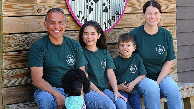 The Tibuni Family, from left, Daniel, Emerson, age 10, Branson, age 6, and Kandice, and sitting in front is 2-year-old Tamera, a standard Poodle. The family all volunteer at 4 Paws For Ability in Xenia. MARSHALL GORBY\STAFF