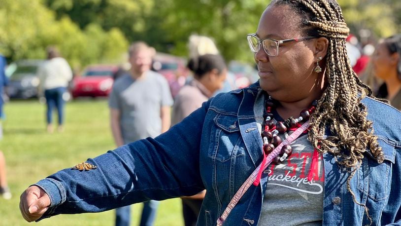 Juan Blanks lends an arm to a butterfly she released in honor of her late mother, Lynn, during an event hosted by Ohio's Hospice of Dayton on Saturday. AIMEE HANCOCK/STAFF