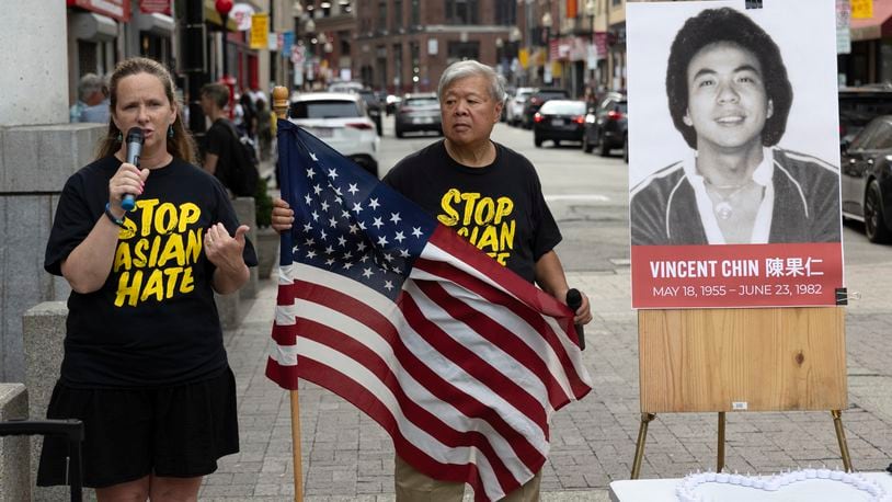 Wilson Lee holds an U.S. flag as Boston City Councilor Erin Murphy speaks during a remembrance ceremony for Vincent Chin in Chinatown, Sunday, June 23, 2024, in Boston. Over the weekend, vigils were held across the country to honor the memory of Chin, who was killed by two white men in 1982 in Detroit. (AP Photo/Michael Dwyer)