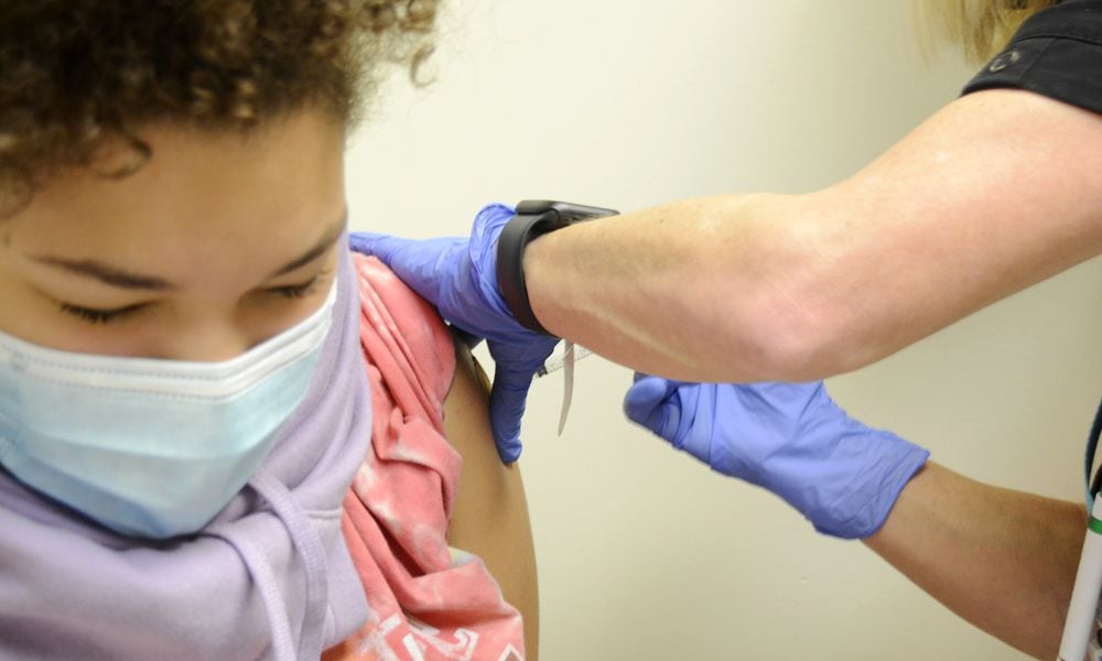 Brooklyn Brundidge, 12, a seventh-grader at Garfield Middle School in Hamilton, receives a vaccine shot on Wednesday, Sept. 14, 2022, from Public Health Nurse Betsy Waldeck at the Butler County General Health District clinic in downtown Hamilton. MICHAEL D. PITMAN/STAFF