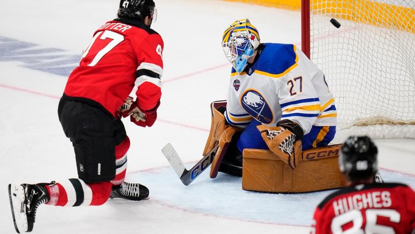 New Jersey Devils' Paul Cotter scores his sides second goal past Buffalo Sabres' Devon Levi during the NHL hockey game between Buffalo Sabres and New Jersey Devils, in Prague, Czech Republic, Saturday, Oct. 5, 2024. (AP Photo/Petr David Josek)