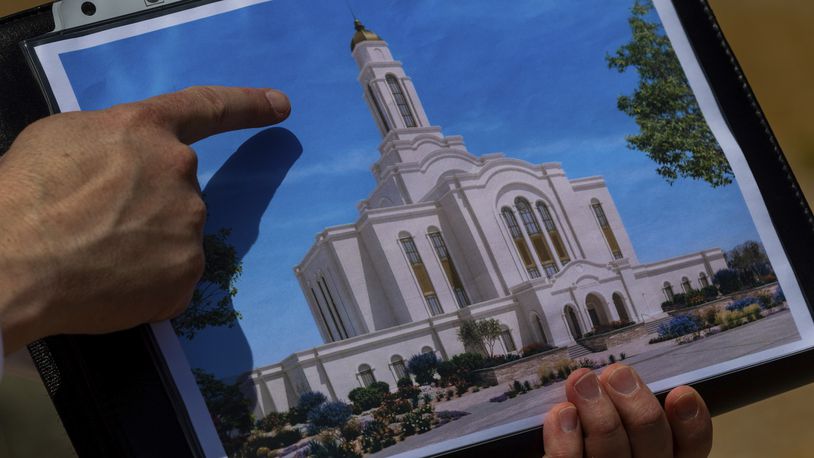 Bud Stoddard, a regional church leader, holds a rendering of the temple planned by The Church of Jesus Christ of Latter-day Saints at a site near Las Vegas, May 16, 2024. (AP Photo/Ty ONeil)