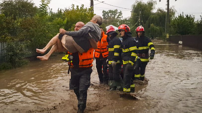 In this photo released by the Romanian Emergency Services Galati (ISU Galati), a rescuer carries an old man in Pechea, Romania, Saturday, Sept. 14, 2024 after torrential rainstorms left scores of people stranded in flooded areas. (Romanian Emergency Services - ISU Galati via AP)