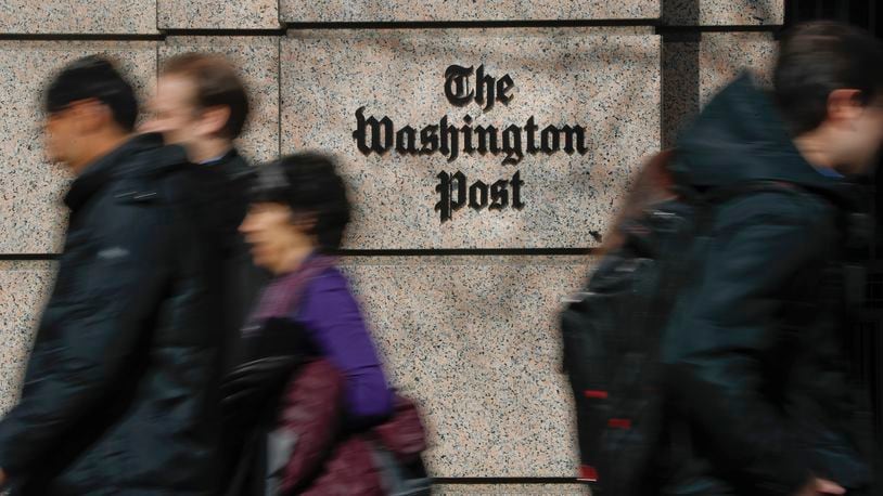 FILE - People walk by the One Franklin Square Building, home of The Washington Post newspaper, in downtown Washington, Feb. 21, 2019. New leaders of The Washington Post are being haunted by their past, with ethical questions raised about their actions as journalists in London that illustrate very different press traditions in the United States and England. (AP Photo/Pablo Martinez Monsivais, File)
