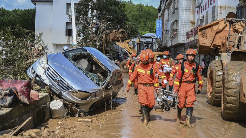 In this photo released by Xinhua News Agency, rescuers carrying rescue equipment enter a flood-affected area in Wuping County of Longyan City, southeast China's Fujian Province, Thursday, June 20, 2024. A family of six was found dead by rescuers in Fujian province, state media reported Saturday, adding to the extreme weather deaths after downpours caused landslides in the area, even as authorities extended a warning of more severe weather ahead. (Zhou Yi/Xinhua via AP)
