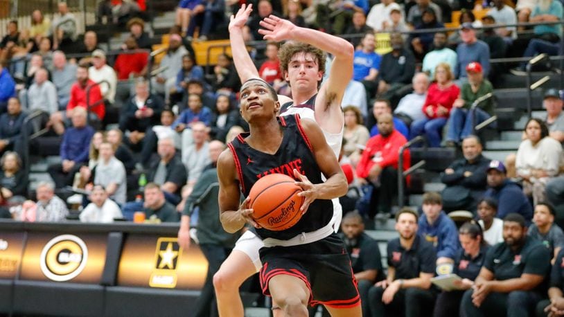 Wayne High School senior Josiah Howard-Morrison drives past Lebanon senior Kyle Koch during their Division I district semifinal game on Monday night at Centerville High School. Howard-Morrison hit a 3-pointer at the buzzer to lift the Warriors to a 73-70 overtime win. Michael Cooper/CONTRIBUTED